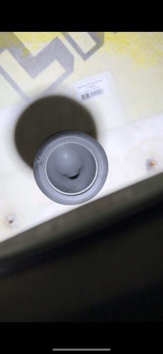 Närbild av insidan av en rörkoppling från en vägghängd Grohe-toalett, eventuellt relaterad till ett vattenläckageproblem.