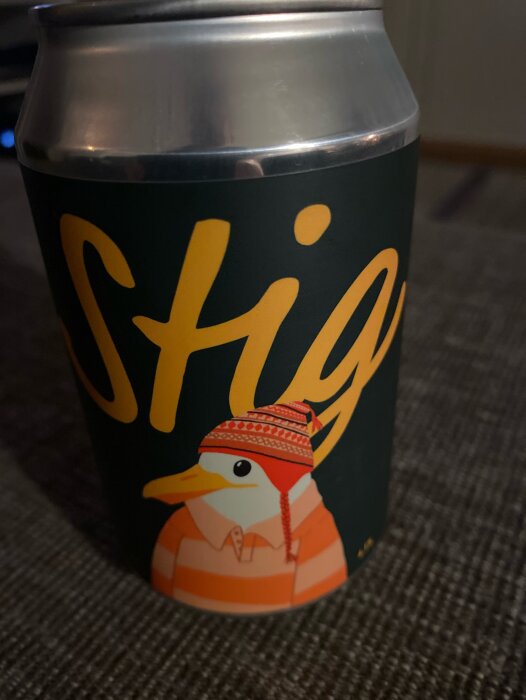 En ölburk från Stigberget med en illustration av en fågel i mössa och randig tröja.