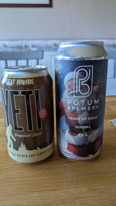 Två ölburkar, en "Yeti Imperial Stout" och en "Potum Brewery Heart of Gold Dubbel 6,5%", på ett träbord inomhus.