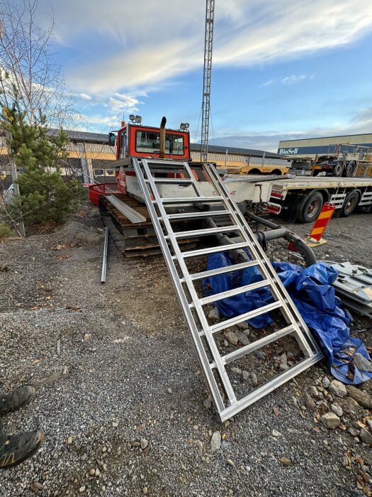 Aluminiumrampsvetsning för snöskoter, lutad mot en pistmaskin.