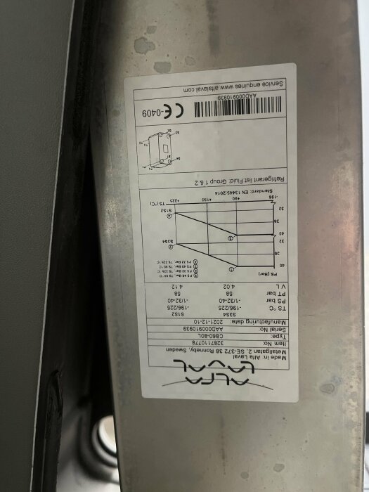 Etikett på metallföremål med teknisk specifikation och streckkod.