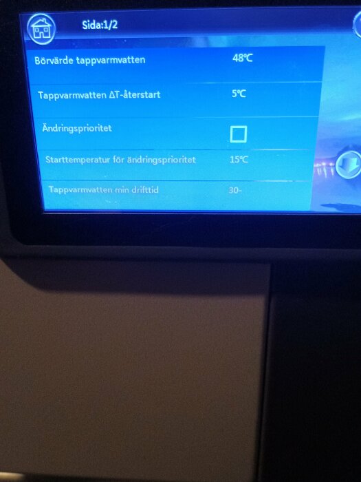 Bild av display med inställningar för tappvarmvatten, inklusive startvärde 48°C och återstart 5°C, på luft/vatten-system.