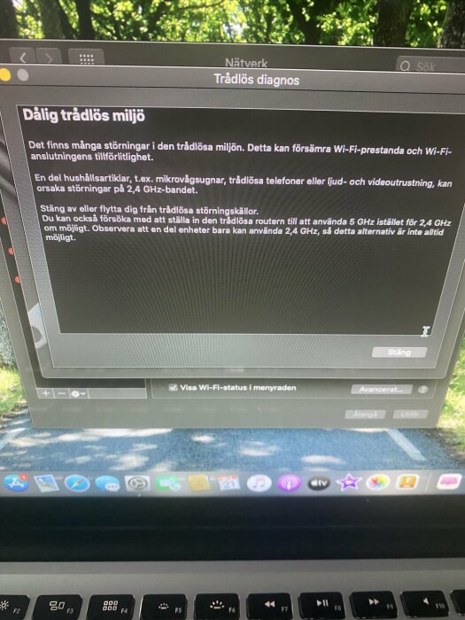 Dator visar fönster med text om dålig trådlös miljö, störningar från hushållsartiklar och rekommendation att använda 5 GHz istället för 2,4 GHz.