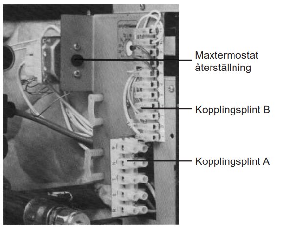 Närbild på kopplingsplintar och maxtemostat-återställning i en kontrollpanel.