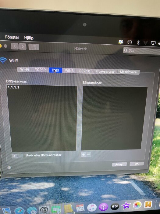 Skärmbild av nätverksinställningar på Mac, visar DNS-flik med 1.1.1.1 som DNS-server och tomt sökdomänfält.