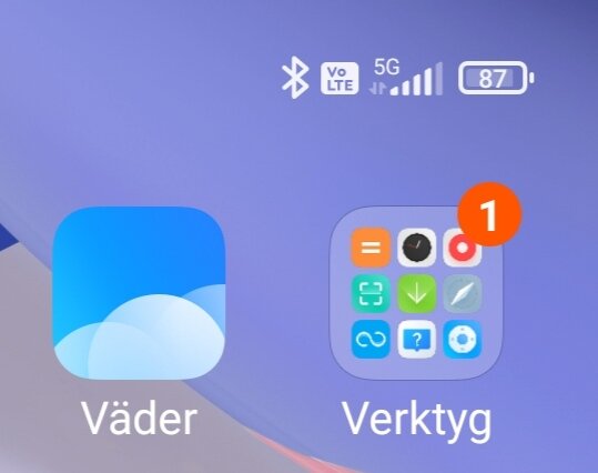 Skärmbild från en mobiltelefon som visar apparna "Väder" och "Verktyg", med en notifiering på verktygsappen och 5G-signalstyrka.