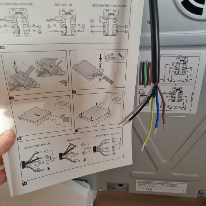 Bruksanvisning för spishäll med kopplingsschema och kabel med fem trådar i olika färger syns.