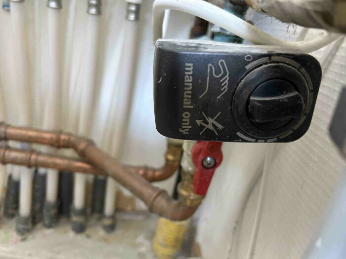 Manuell ventil med vridhandtag på värmerörsystem, sannolikt Siemens, del av installation för golvvärme och radiatorer.