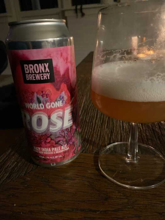 Burk med Bronx Brewery World Gone Rosé, en hazy pale ale, och ett glas med öl på ett träbord.