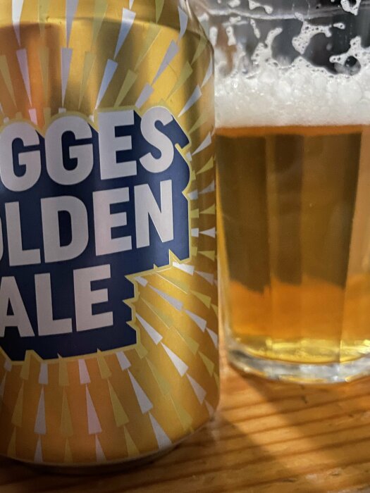 Burk med Dugges Golden Ale och ett glas öl på ett bord.