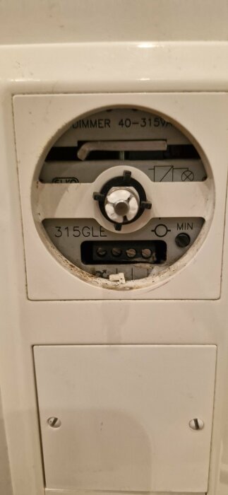 Närbild av en Elko RS 315GLE dimmer med saknad ratt, visande exponerade mekanismer och märkningar.