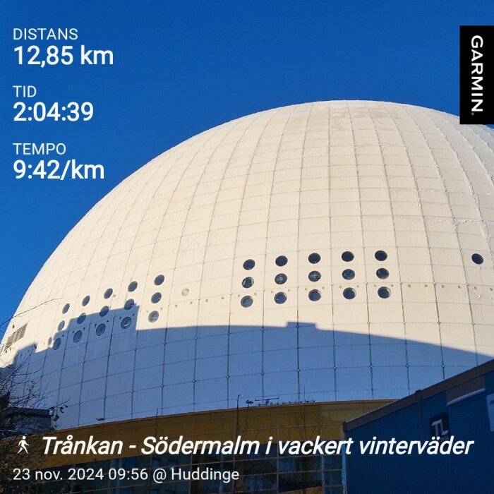 Vit kupolformad byggnad mot klarblå himmel, text visar distans 12,85 km, tid 2:04:39, tempo 9:42/km, gåtur i vackert vinterväder.