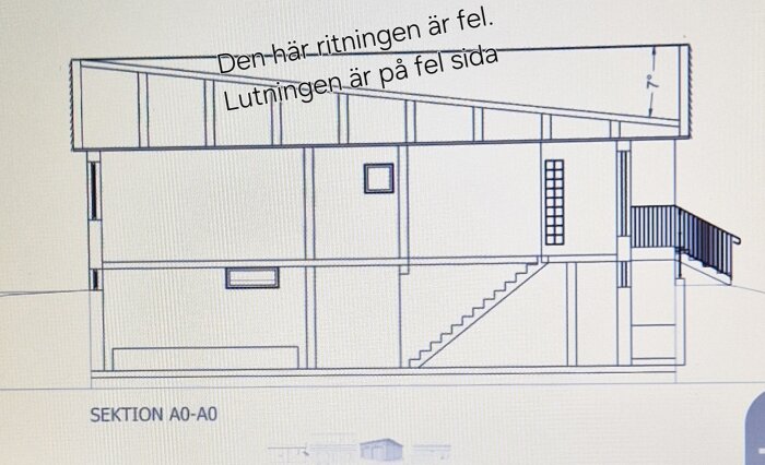 Arkitektritning av hus med pulpettak, text på ritningen säger "Den här ritningen är fel. Lutningen är på fel sida".