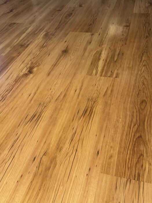 Trägolv med ådring och varierande nyanser av brunt.