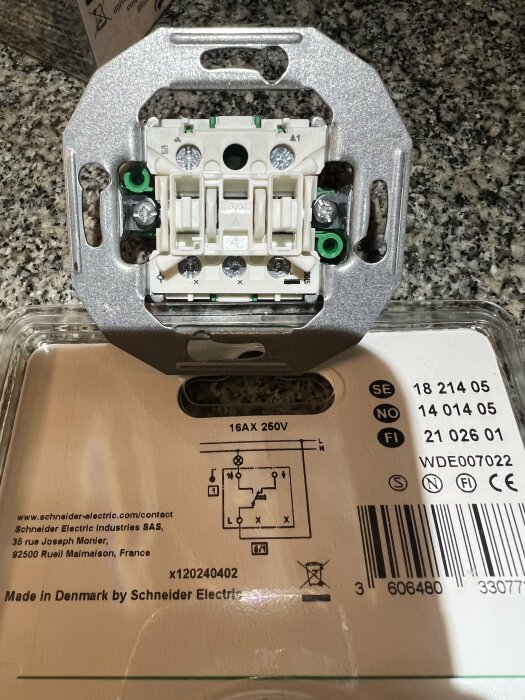 Närbild på en Schneider Electric brytare med etikett som visar elektriska specifikationer och kopplingsschema, 16AX 250V uppmärkt på förpackningen.