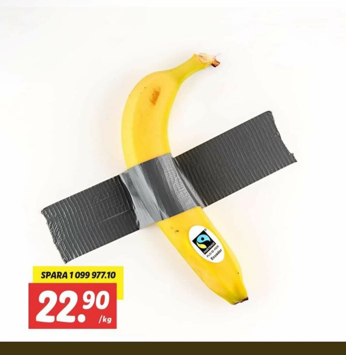 Banana tejpad mot en vägg med silvertejp, med en Fairtrade-märkning. Prislapp visar 22.90 kr/kg.