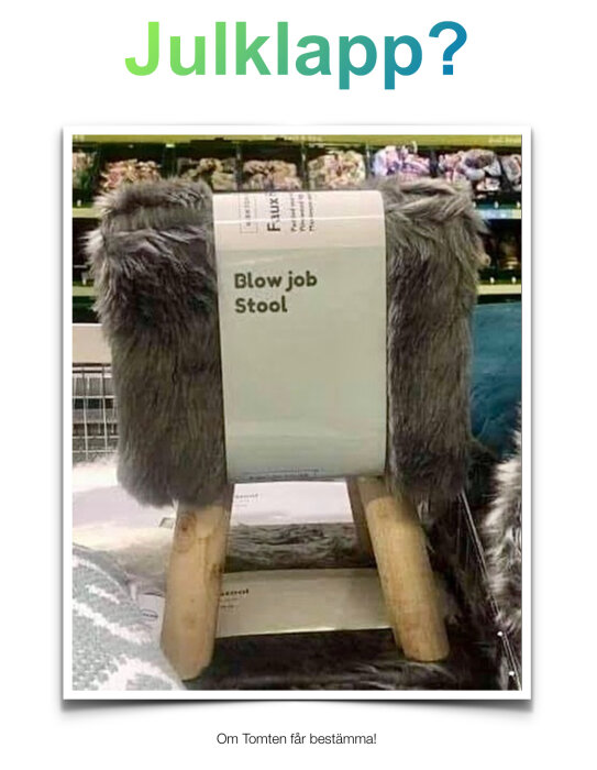 En träpall med grå fuskpäls och humoristisk etikett, "Blow job Stool", i en butik som möjligt julklappsförslag.