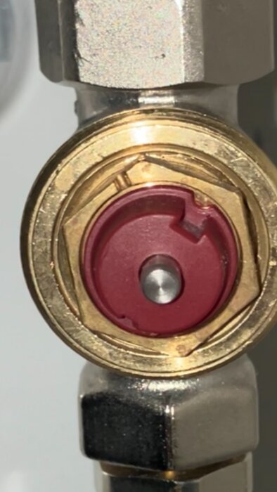 Närbild av röd ventil på ett IHI element utan termostat, med mässings- och metallkomponenter synliga.