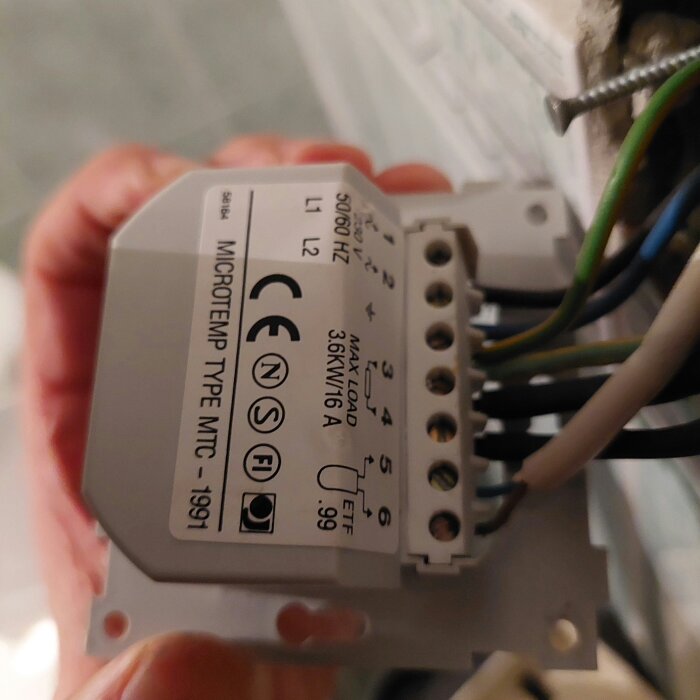 Gammal golvvärmetermostat med kopplingsschema, märkt Microtemp Type MTC-1991. Visar anslutningar för L1, L2 och jord samt specifikationer.