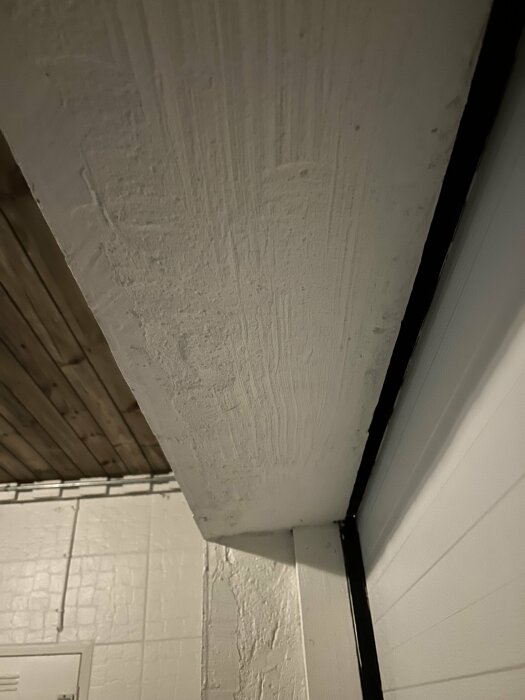 Betongtak ovanför en inmurad garageport från 90-talet, potentiell plats för installation av spotlights.