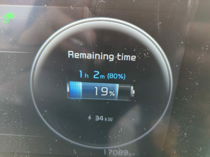 Bilden visar en bils laddningsskärm med återstående laddningstid på 1 timme och 2 minuter, batterinivå på 19% och laddningsstyrka 34 kW.
