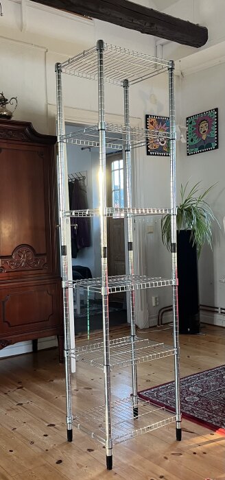 Stor, trådig förvaringshylla från IKEA monterad i ett rum med trägolv och inredning, perfekt för vedförvaring.