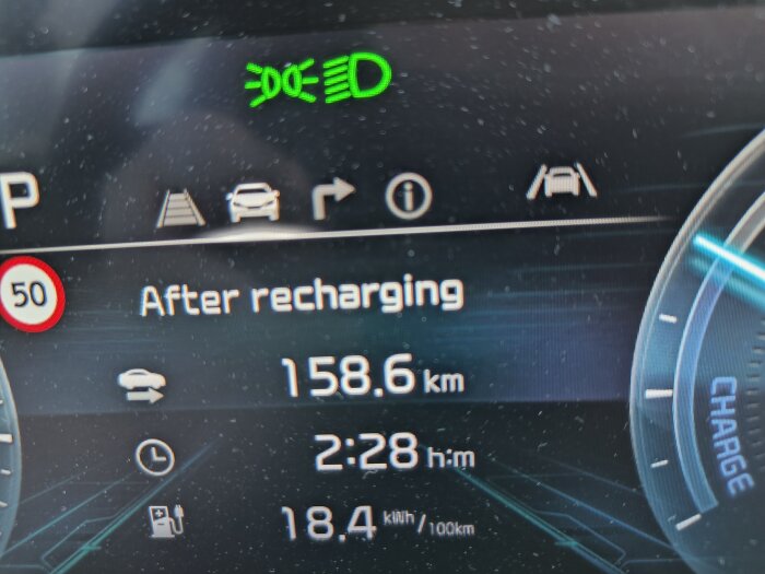 Instrumentpanel som visar laddningsstatus med texten "After recharging", räckvidd 158.6 km, tid 2:28 h:m och förbrukning 18.4 kWh/100 km.