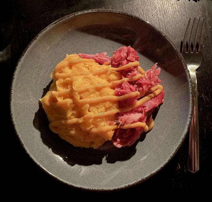 Tallrik med fläsklägg och rotmos, garnerat med såspartier.