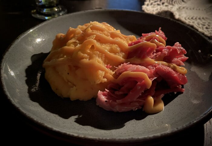 Tallrik med fläsklägg och rotmos av potatis, morot, kålrot och sötpotatis.