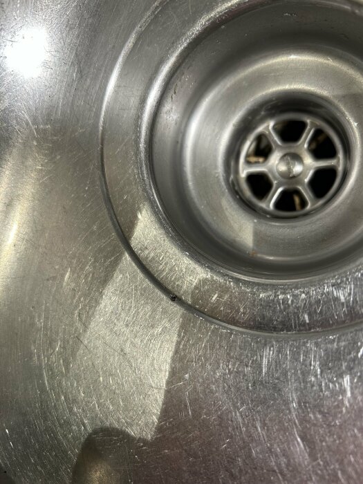 Diskho med ett hål och tidigare lagningstejp synlig. Fråga om bästa sättet att laga hålet tillfälligt innan köksrenovering.