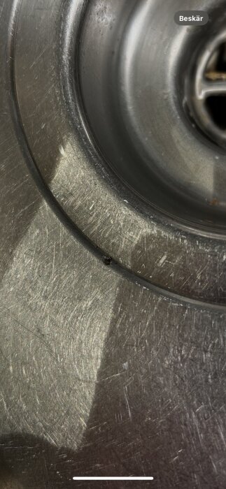 Närbild av diskho med ett litet hål omgivet av reparationsband.