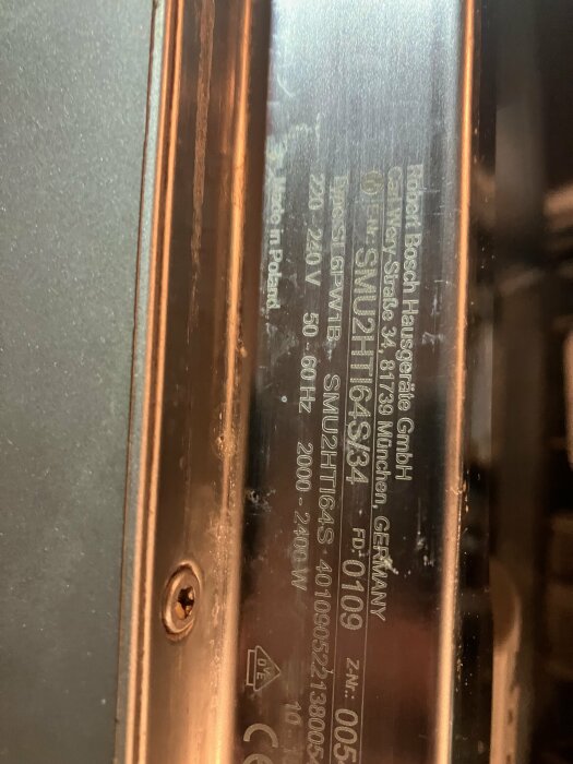 Närbild på en Bosch tillverkningsskylt med serienummer och teknisk information på en köksapparat. Tillverkad i Polen.