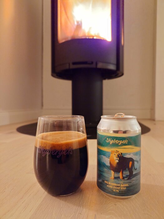 Ett glas mörk stout och en ölburk med en lejonbild, framför en sprakande vedkamin.