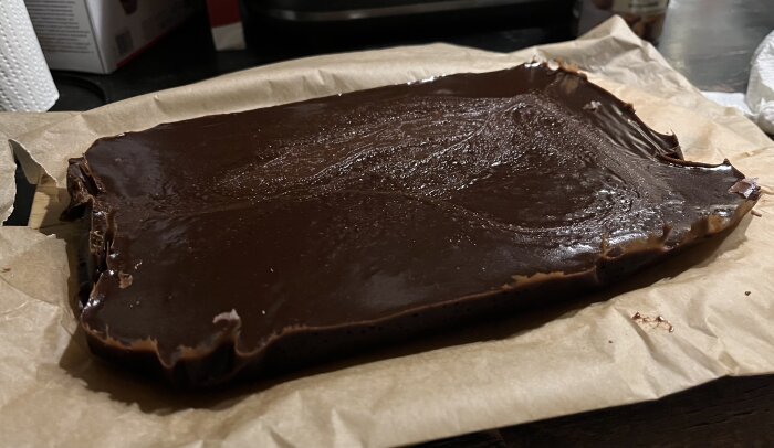 Hemlagad chokladkola med Baileys på bakplåtspapper, redo att skäras och ges bort som julpresent.