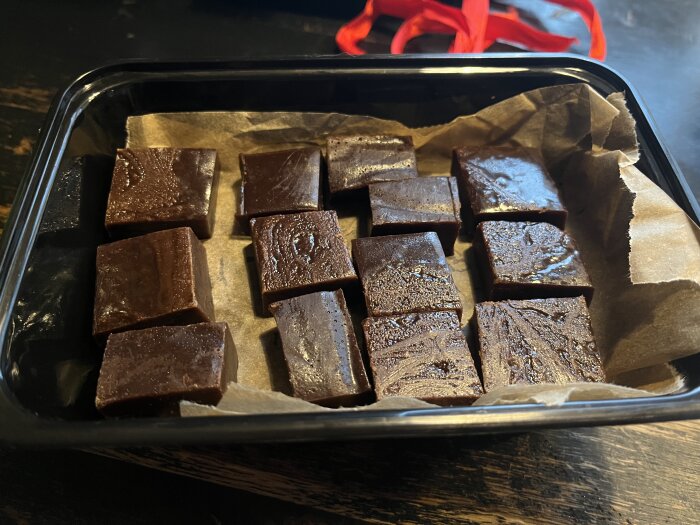 Hemlagad chokladkola med Baileys i en svart form, redo för att ges bort som julpresent.