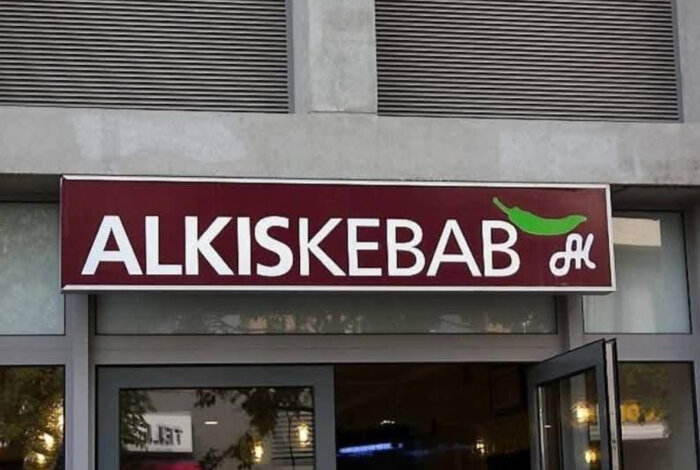 Skylt ovanför entrén till "Alkiskebab" med illustrerad grön chili.