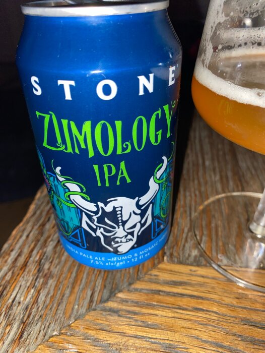 Blå burk med Stone Zumology IPA och ett glas öl på ett träbord.