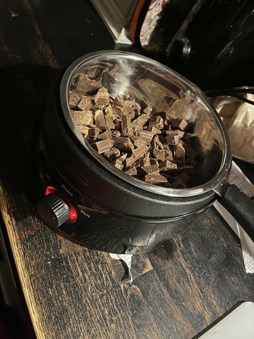 Chokladbitar smälter i en kastrull på en spishäll inför tillverkning av Rocky Road-godis.