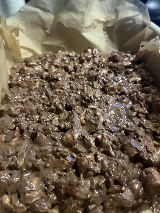 Rocky Road med smält choklad, jordnötter, cashewnötter, Polly, bilar och minimarshmallows på bakplåtspapper.