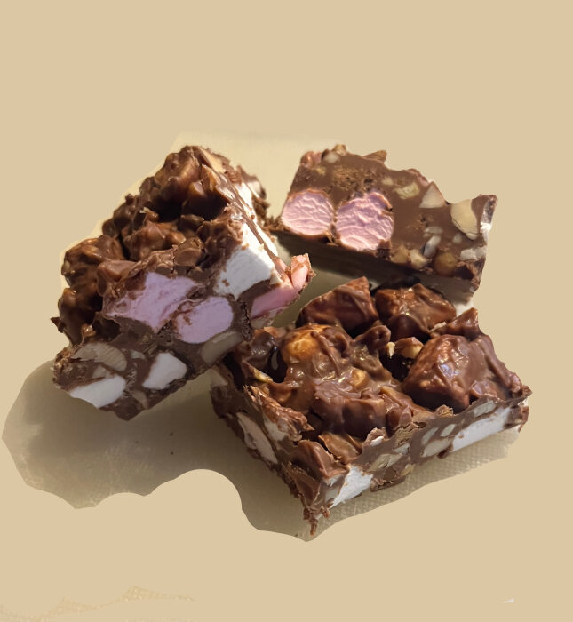 Hemgjord rocky road med jordnötter, cashewnötter, polly, bilar, minimarshmallows och daimchoklad, skuren i bitar och upplagd på en yta.