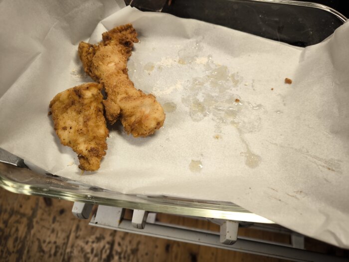 Friterade kycklingbitar på bakplåtspapper efter att ha prövats ett hemmagjort Zinger-recept inspirerat av KFC.