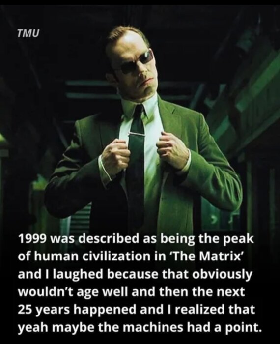 En man i kostym med solglasögon justerar sin slips, text om "The Matrix" och år 1999 som topp för mänsklig civilisation syns.