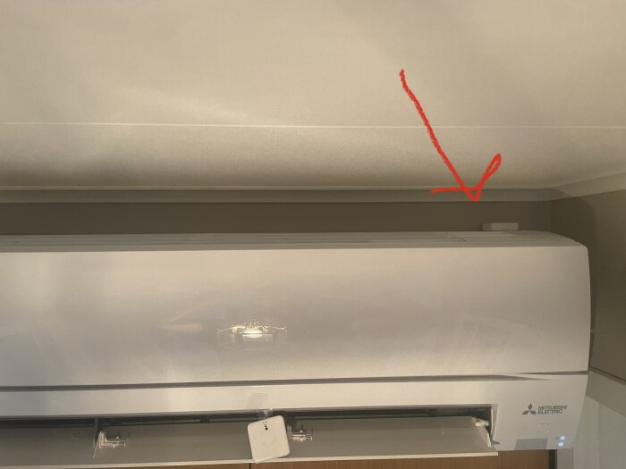Temperaturmätare flyttad till höger ovanpå luftkonditioneringsenheten, markerad med en röd pil.