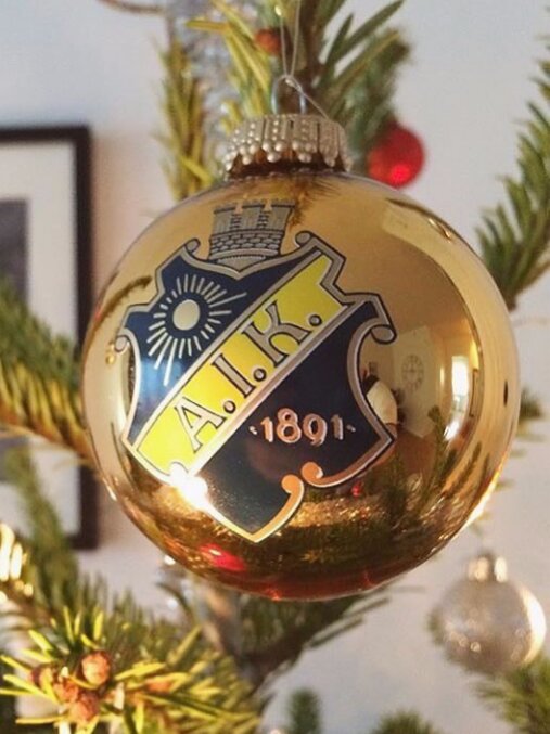 Julgranskula med AIK:s emblem hängande på en gran.