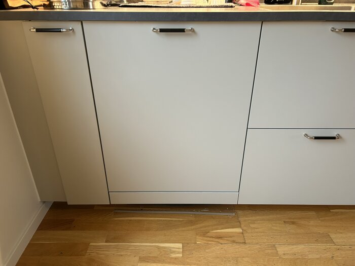 IKEA-köksskåp med anpassad lucka för Bosch diskmaskin, fastsatt med magneter för justerbar montering.