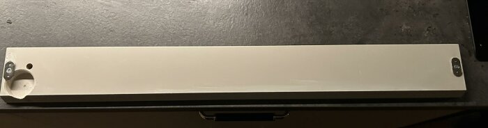 Kapad kökslucka med två vinkeljärn monterade i hörnen för att passa en integrerad diskmaskin.