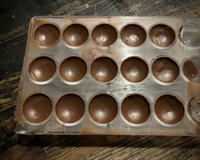 Silikonformar fyllda med choklad, praliner sitter fast. Första försök med hårdplastform för pralinprojekt, chokladen svårt att lossna från formen.