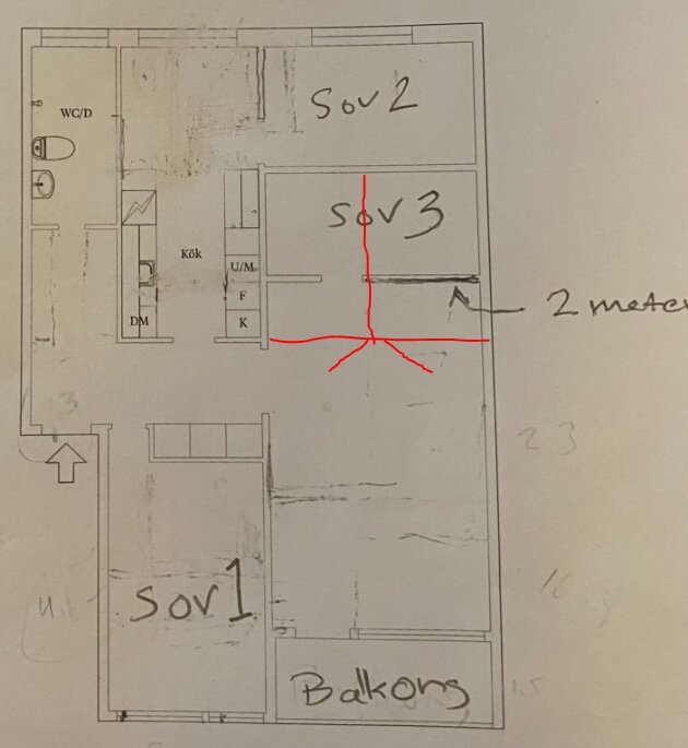 Handritad planlösning av lägenhet med markerade sovrum, varav två saknar fönster. Förslag på förändring med röda linjer för ny väggplacering.