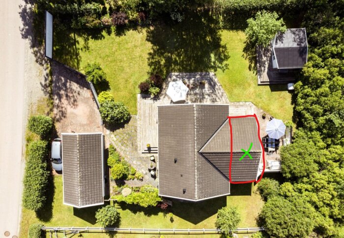 Flygbild av hustak med markerat område i rött och grönt kryss där en vägg ska rivas och en ny ska byggas om, omgiven av grönska och uteplats.