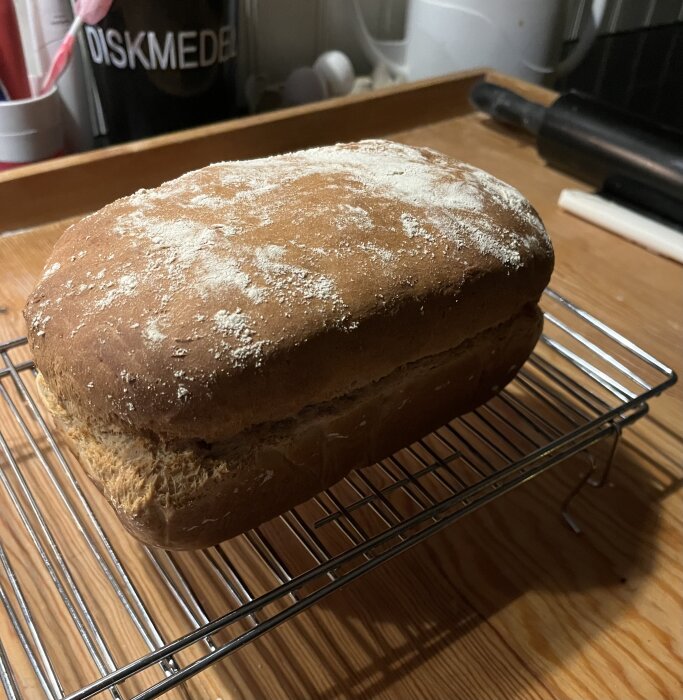 Nygräddad frukostlimpa på galler i köksmiljö, täckt med mjöl.